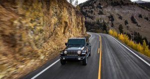 A Jeep Wrangler driving down a mountain road.